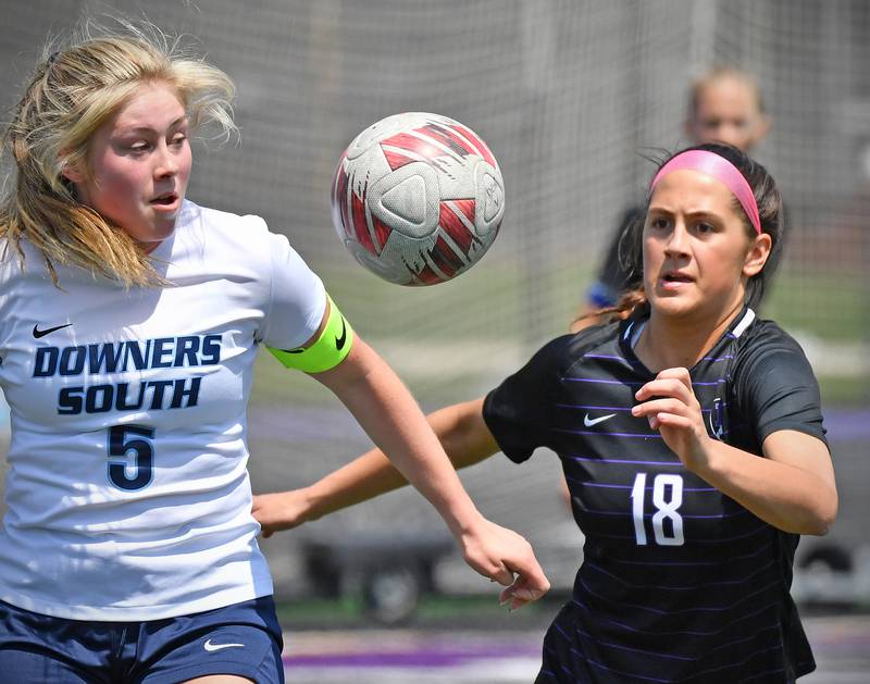 Downers Grove South’s Sienna Thurston (5) and Downers Grove North’s Campbell Thulin (18) go after a high bounce during a game on May 10, 2025 at Downers Grove North High School in Downers Grove .