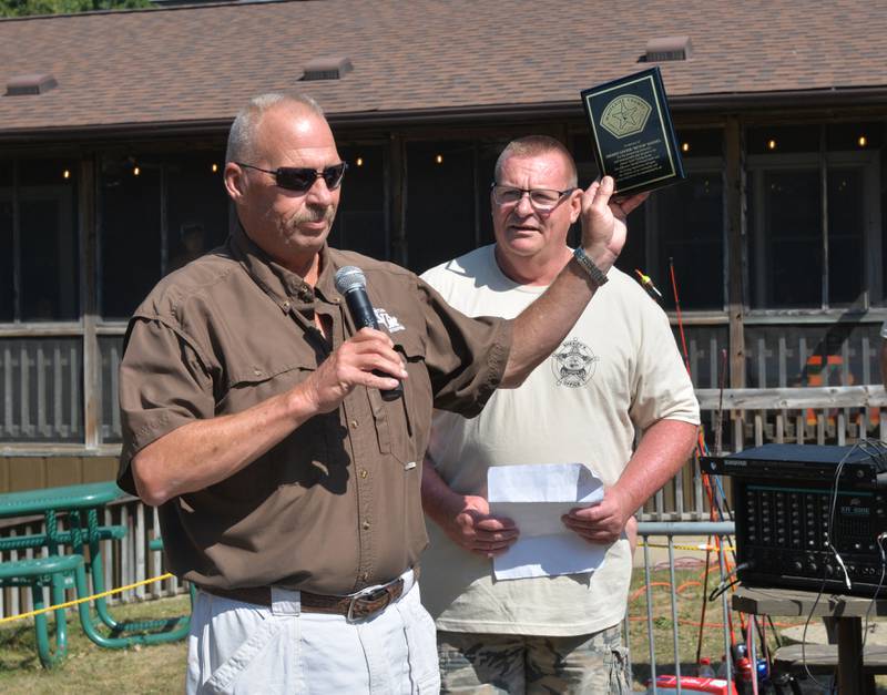 Jeff Kimmel, son of former Whiteside County Sheriff Lester "Butch" Kimmel accepts an appreciation plaque as current sheriff John Booker listens at the Whiteside County Sheriff Office and Mounted Patrol's annual fishing derby at Morrison-Rockwood State Park in Morrison on Saturday, Sept. 9, 2023.