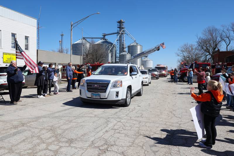 Willy VanWassenhove, seated in the front passenger seat, is greeted by friends, family and numerous rural fire departments along Main Street in Cabery upon his return home to the area on Saturday, March 22, 2025. VanWassenhove hasn't been home since September 20 when his hayrack was struck on the side of the road, leaving him seriously injured.