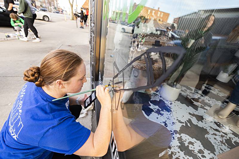 Volleyball setter Denali Stonitsch paints a rocket on the window of Mud and Moo in downtown Rock Falls Monday, Nov. 6, 2023. The Rock Falls team plays for the state title this weekend.