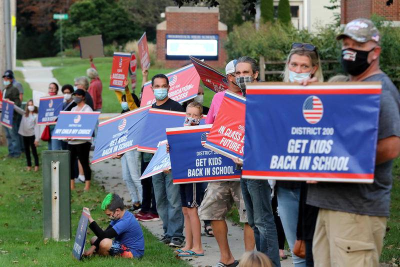 About 35 parents and students assembled Sept. 22 with signs and chants to reopen schools for in-person learning during a rally held at Woodstock High School in Woodstock.