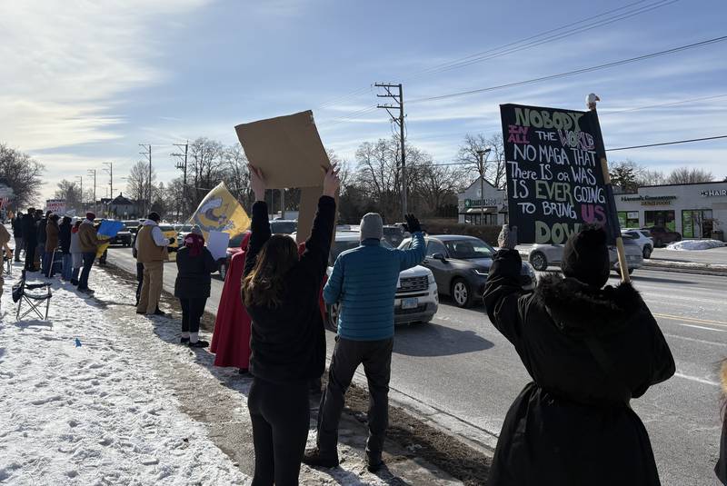 Protesters hold signs at a protest in McHenry Feb. 1, 2026.
