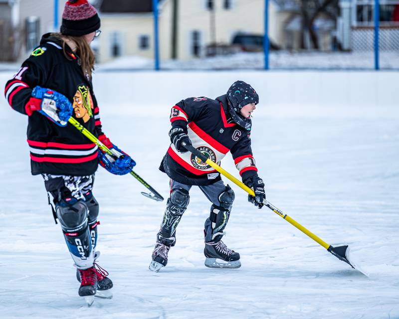 Jack Yuska shovels snow on ice rink whilst skating at Schweickert Arena's Ice Rink on Tuesday, December 30, 2025, at Washington Park in Peru.