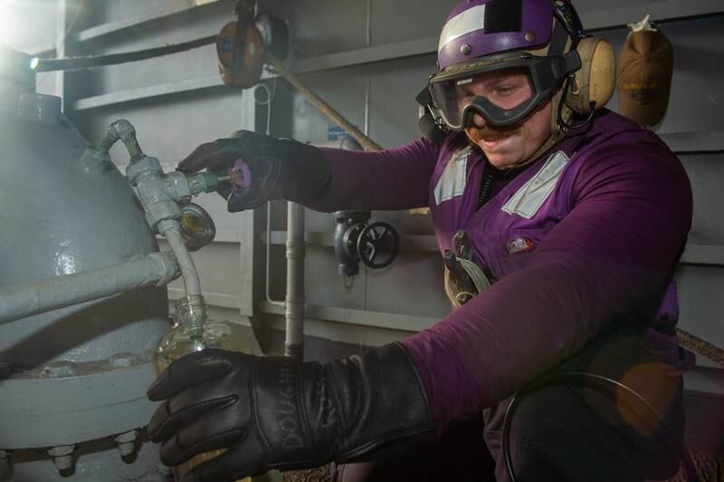 Aviation Boatswain’s Mate (Fuel) 3rd Class and Marengo native Andre Dougherty takes a fuel sample on a weather deck aboard USS Harry S. Truman during a replenishment-at-sea with USNS Supply on June 17, 2022.