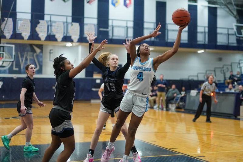 Downers Grove South's Hayven Harden (4) shoots the ball in the post against Oswego East's Desiree Merritt (21) and Cassie Van Meter (13) during a 4A Oswego East Regional semifinal girls basketball game at Oswego East High School on Monday, Feb 12, 2024.