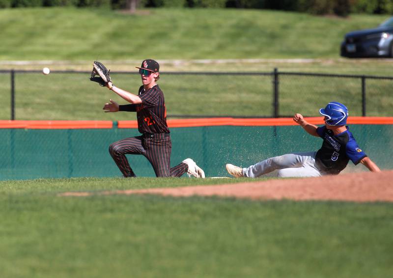 Geneva's Nelson Wendell slides safely into third base as St. Charles East's Andrew Evans gets the throw during a game on Tuesday, May 13, 2024 in St. Charles.