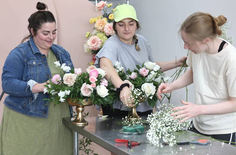 Willrett Flower Company Owners Mary Grace McCauley (left) and her sister Kat Willrett along with design assistant Lauren Hopkins (right) build some arrangements Friday, May 13, 2022, in the store at 302 E. Lincoln Highway in DeKalb. The location will soon be filled with flowers and gift items as they get ready for the opening in June.