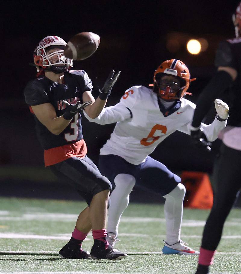 Maine South's Thomas Naughton (3) reels in an interception over Evanston's Andrew Barker (6) Friday October 20, 2023 in Park Ridge.