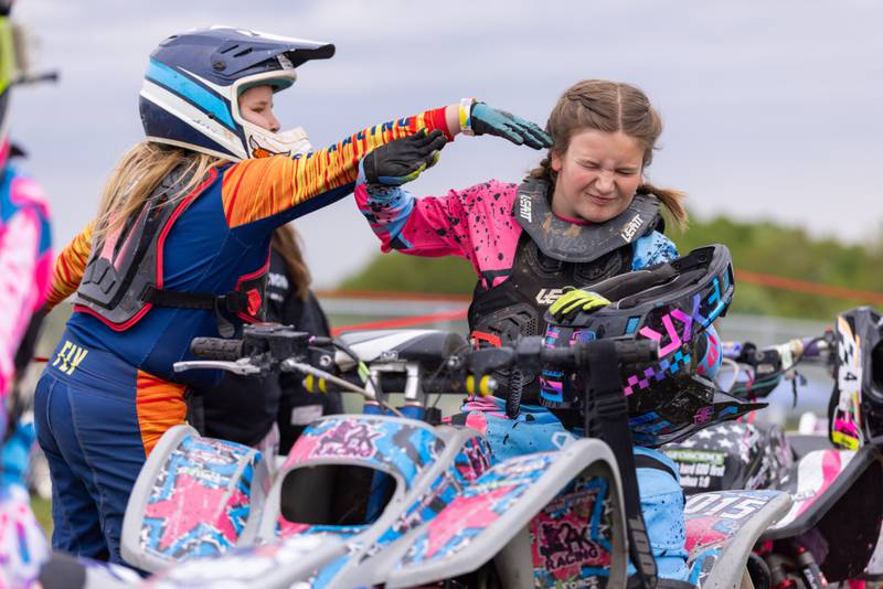 Maci Howard (left) playfully taps the head of her friend Kayleigh Murphy (right) prior to the start of their race during the ATVMX Championship race on May 24, 2025 at Sunset Ridge MX in Walnut. The girls have been long time friends as they race the entire circuit together.