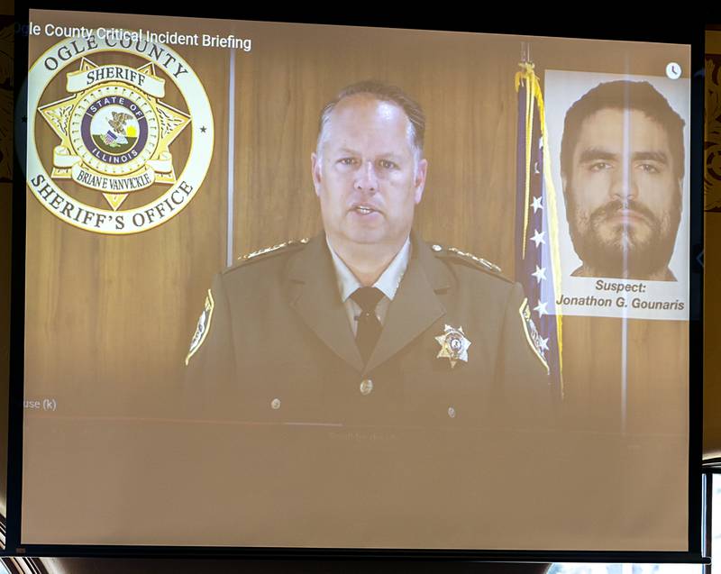 Ogle County Sheriff Brian VanVickle appears on screen with a photo of  Jonathon Gounaris on Tuesday, June 18, 2024. VanVickle showed the Ogle County Board video from the body cam of an officer responding to last week’s standoff.