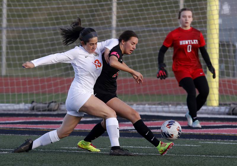 Huntley's Jaci Laramie (center) kicks the ball away from Crystal Lake Central's Jordin Gaunaurd (left) and Huntley' goalkeeper Ashlyn Grabs watches the play during a Fox Valley Conference  soccer match on Tuesday, April 15, 2025, at Huntley High School.