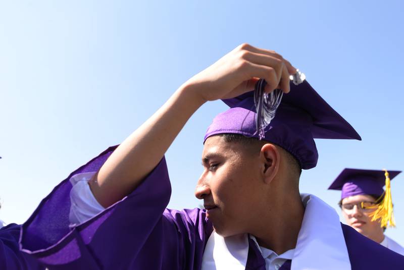 Downers Grove North graduates including  Frank Goiz adjusts switch the side of their tassels  during the graduation ceremony held Sunday May 21, 2023.