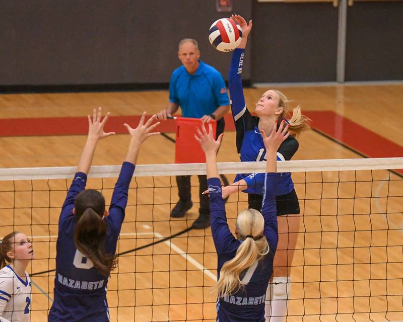 Geneva's Emma Peterson (15) spikes the ball past Nazareth Academy defenders during the sectional title game on Thursday Nov. 6, 2025, held at Timothy Christian High School.
