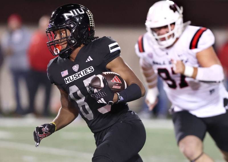 Northern Illinois' Trayvon Rudolph runs ahead of Ball State's John Harris during their game Tuesday, Nov. 7, 2023, in Huskie Stadium at NIU in DeKalb.