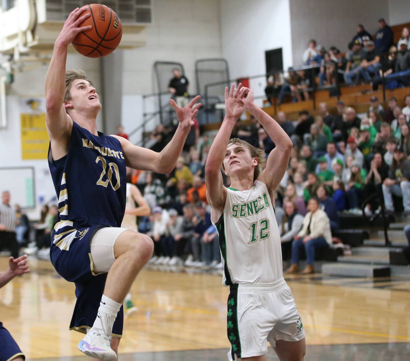 Marquette's Logan Nelson scores a on a drive to the basket over Seneca's Braden Ellis during the Tri-County Conference championship game on Friday, Jan. 27, 2023 at Putnam County High School.