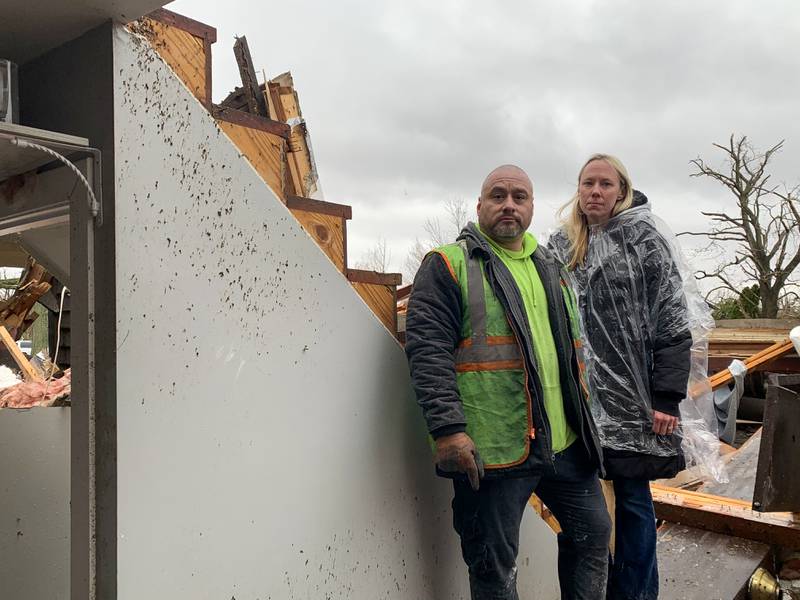 Jesse and Kendahl Garcia stand inside their roofless home on Shaftsbury Road in Aroma Park on March 11, 2026 following a March 10 tornado that passed through Kankakee County.