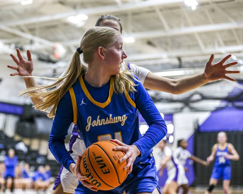 Johnsburg's Carlie Majercik (21) is defended after grabbing a rebound during their basketball game between Johnsburg at Plano, Monday Dec 16, 2024 in Plano.