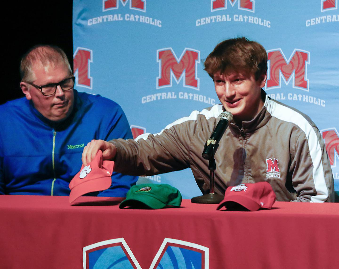 Christian Bentancur, flanked by his father, Patrick, grabs the Clemson cap as he announces Friday, Jan. 13, 2023, that he will attend Clemson University to play Division I football, at Marian Central High School. Bentancur, a highly recruited tight-end, narrowed his section down to Clemson from his final three colleges. The other two colleges were Ohio State and Oregon universities.