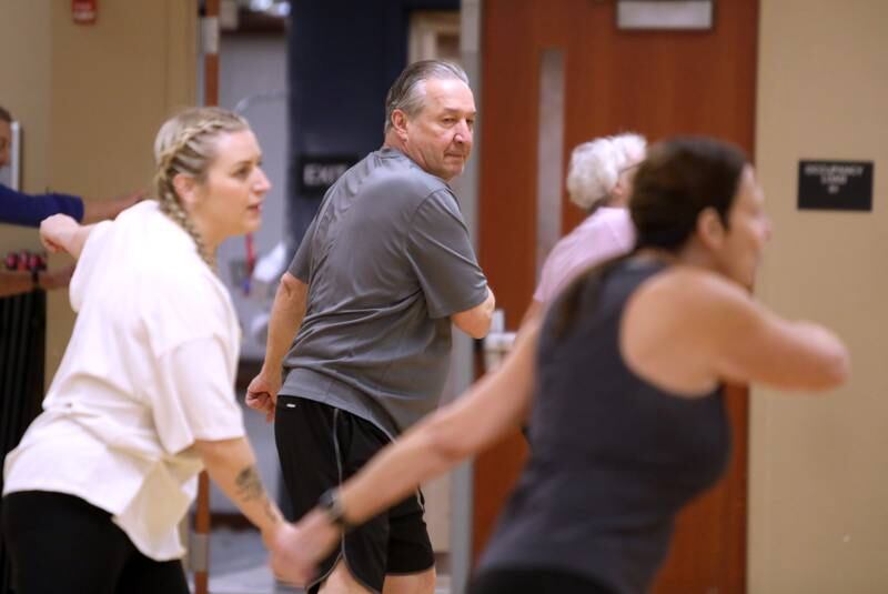 Jim Samata (center) and his daughter, Angel Samata (left) follow instructor Joan Bry during a fitness class for active older adults at Ackerman Sports and Fitness Center in Glen Ellyn on Friday, Jan. 5, 2024.