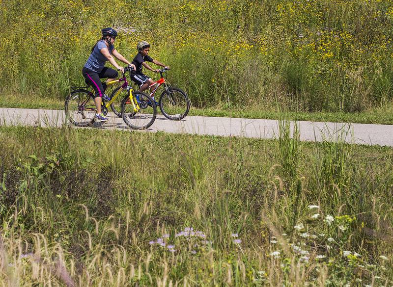 Susie Zels and her son Alaxander, of Cary, ride along a bike path through Hoffman Park Monday, Aug. 18, 2014, in Cary.