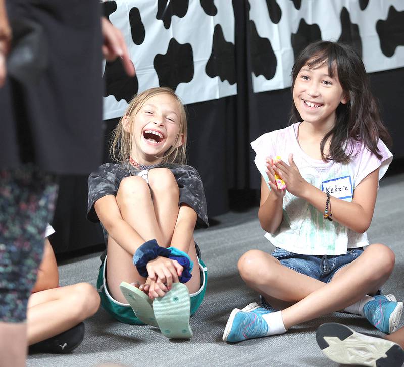 Keera Bengford-Breneisen (left) 9, from DeKalb and Kedzie Kaiser, 9, laugh as volunteer makes a joke Monday, July 11, 2022, during of a session of Summer Reading Vacation put on by Neighbors' House in DeKalb in conjunction with the DeKalb County Farm Bureau. Christ Community Church is hosting the camp this week in their outreach center on North 6th Street in DeKalb.