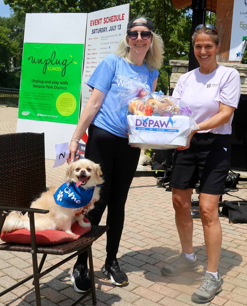 Batavia Park District Executive Director Allison Niemela (far right) presents Deanie the dog and her owner Christine Butcher (on left) the prize for Best Kisser in the Pet Competition at the Windmill City Festival in Batavia on Saturday, July 13, 2024 in Batavia.
