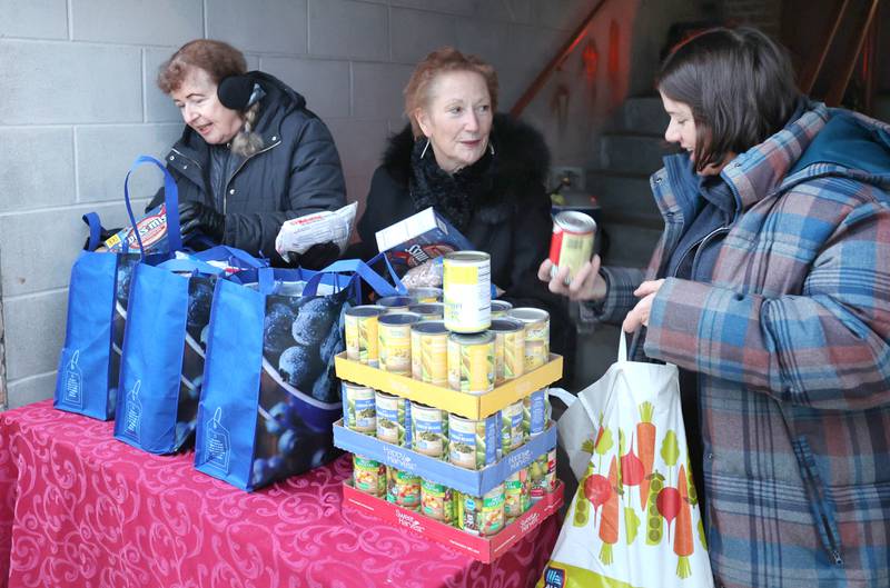 Stage Coach Players Outreach Committee members Deb Brubaker, (left) Jan Kuntz and Angela Schiola (right) sort donations and pack bags Tuesday, Nov. 15, 2022, while collecting donations at the theater in DeKalb for their Thanksgiving food drive. The group is working with the Salvation Army to put together Thanksgiving meals for local families in need.