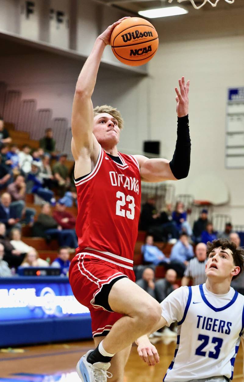 Ottawa's Owen Sanders takes in a layup ahead of Princeton's Hayden Sayler Tuesday night at Prouty Gym. The Pirates won 73-43.