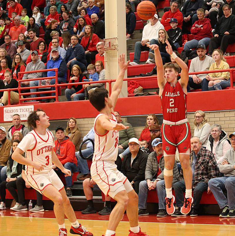 L-P's Seth Adams drains a three point basket over Ottawa's Levi Sheehan and Payton Knoll in Kingman Gymnasium on Friday, Feb. 10, 2023 at Ottawa High School.