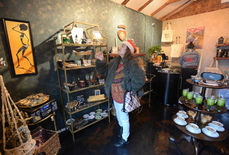 Claudia Nunez of Berwyn enjoys the smell of an incense stick while shopping at the Berwyn Holiday Pop-Up Market Saturday Dec 10, 2022.