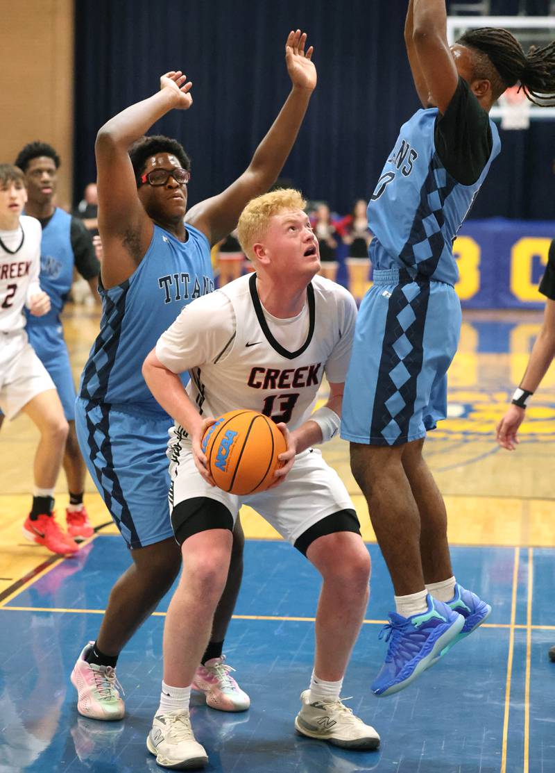 IMSA’s Lota Onwuameze (left) and Benjamin Dixson surround Indian Creek's Isaac Willis Friday, Feb. 6, 2026, during their Little 10 Conference championship game at Somonauk High School.