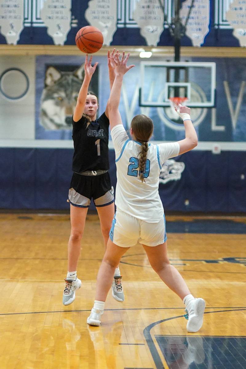 Oswego East's Aubrey Lamberti (1) shoots a three pointer against Downers Grove South's Megan Ganschow (20) during a 4A Oswego East Regional semifinal girls basketball game at Oswego East High School on Monday, Feb 12, 2024.