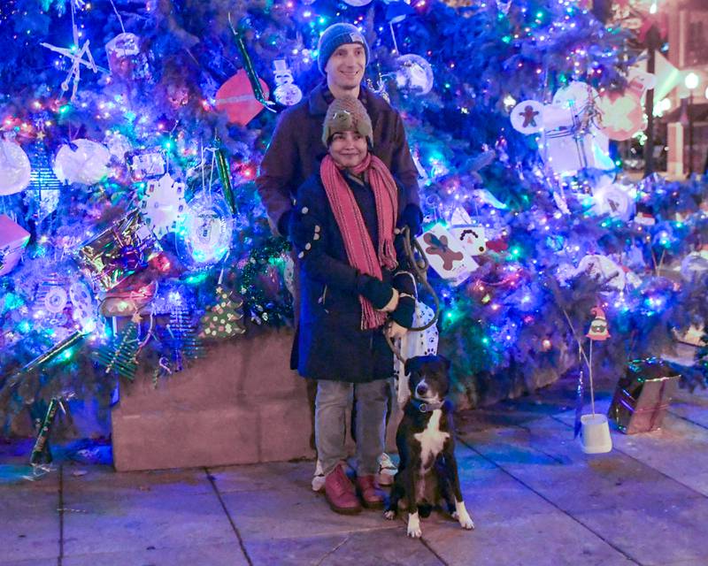Sohinee Roy Williams along with her husband Nathan Williams and Luna a border hound mix, 3, from Downers Grove North pose for a photo after the Christmas tree lighting ceremony on Friday Nov. 29, 2024, held in downtown Downers Grove.