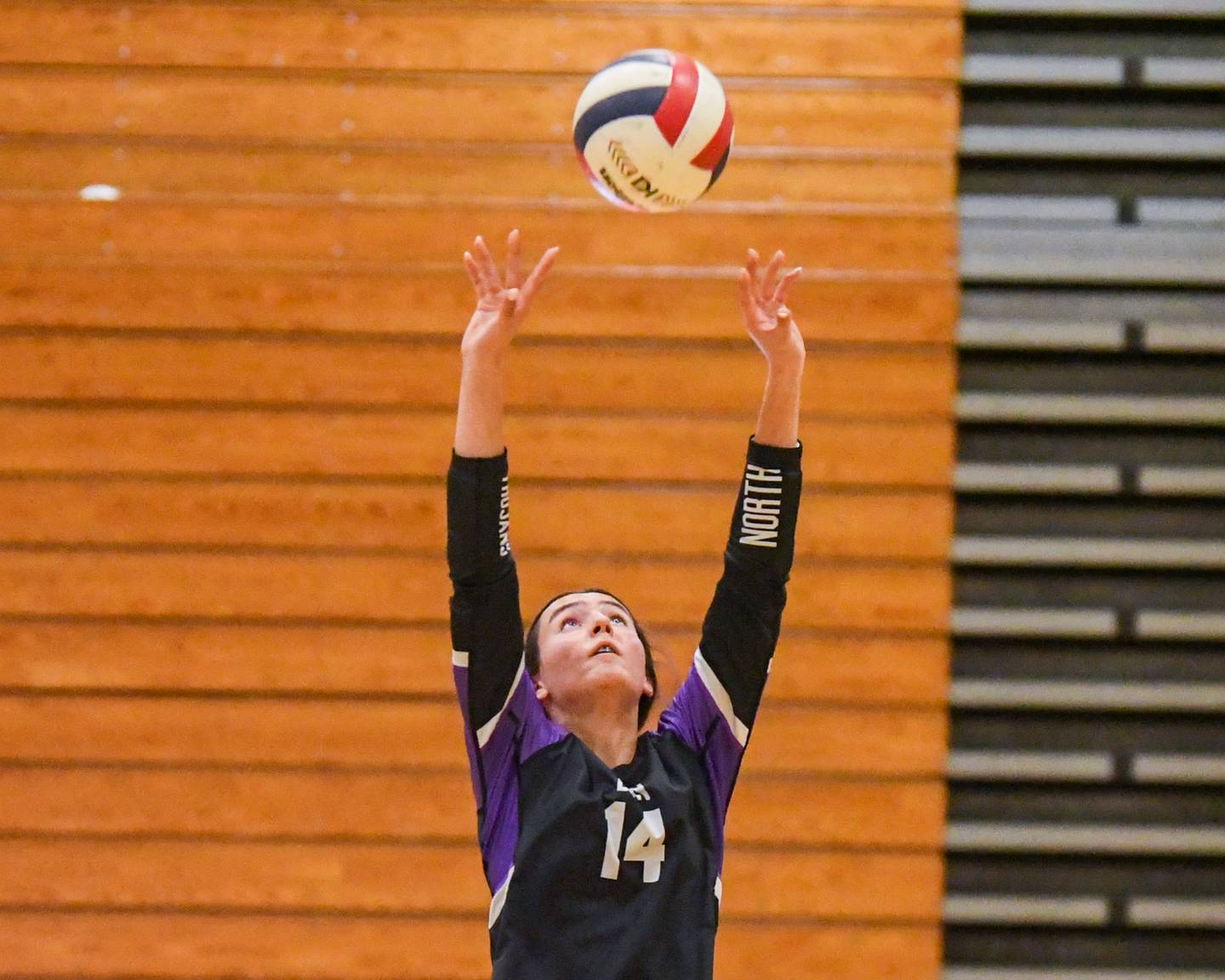 Downers Grove North's Ellery Cabaj (14) sets the ball during the game on Tuesday Oct. 22, 2024, while traveling to take on York High School in Elmhurst.