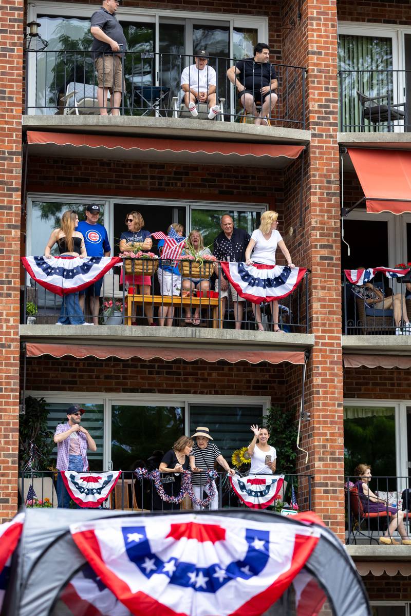 Spectators watch Glen Ellyn’s “4th of July Parade” process up Main Street from their balconies on Friday, July 4, 2025.