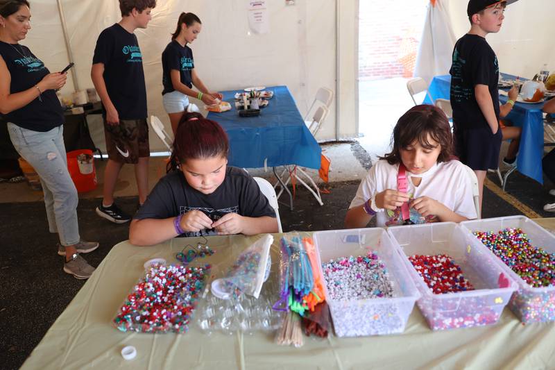 Bella, left, and Gia make friendship bracelets in the Craft Tent at the Saint Dennis and Joseph Catholic Academy Annual Oktoberfest on Saturday, Oct. 5, 2024 in Lockport.