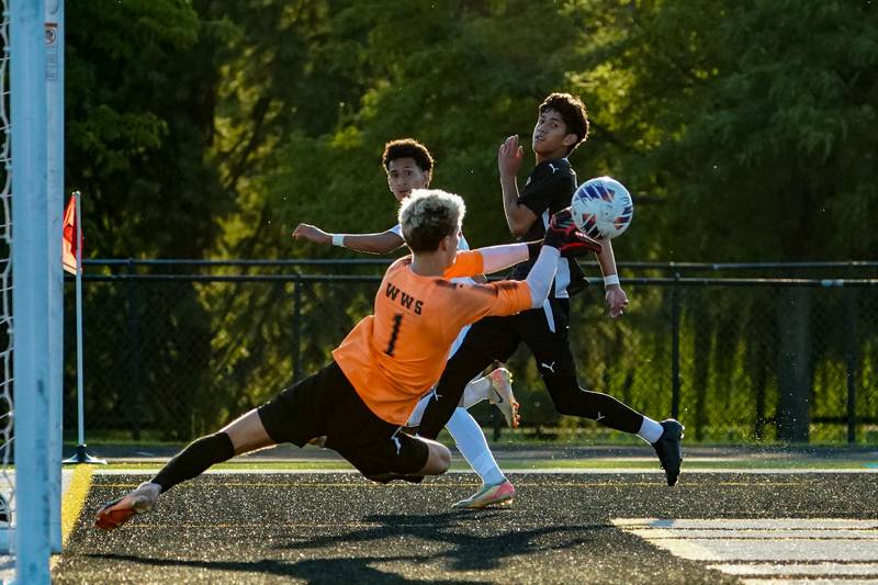 Wheaton Warrenville South's Daniel Karajic (1) makes a diving save against Oswego’s Alexander Nieves (23) during a soccer match at Wheaton Warrenville South in Wheaton on Thursday, Aug 28, 2025.
