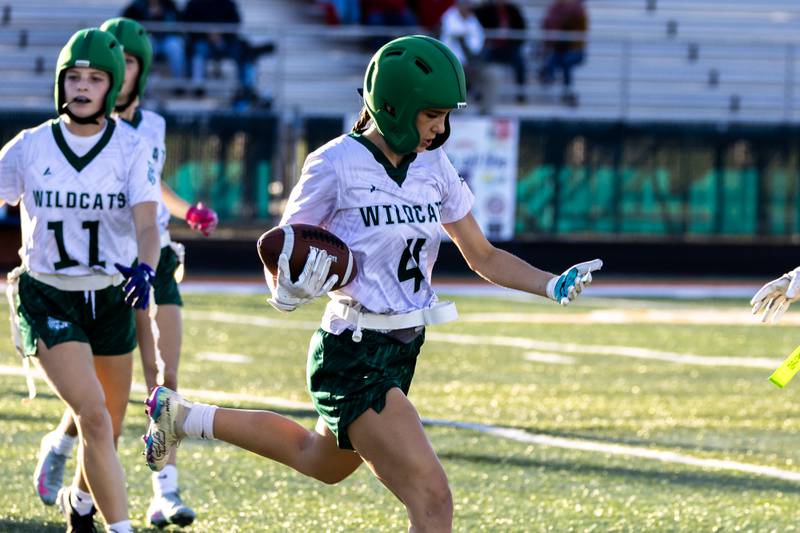 Plainfield Central's Alyssa Page picks-up yardage during a varsity flag football Romeoville Regional semifinal game against Bradley-Bourbonnais at Romeoville on Oct. 7, 2025.