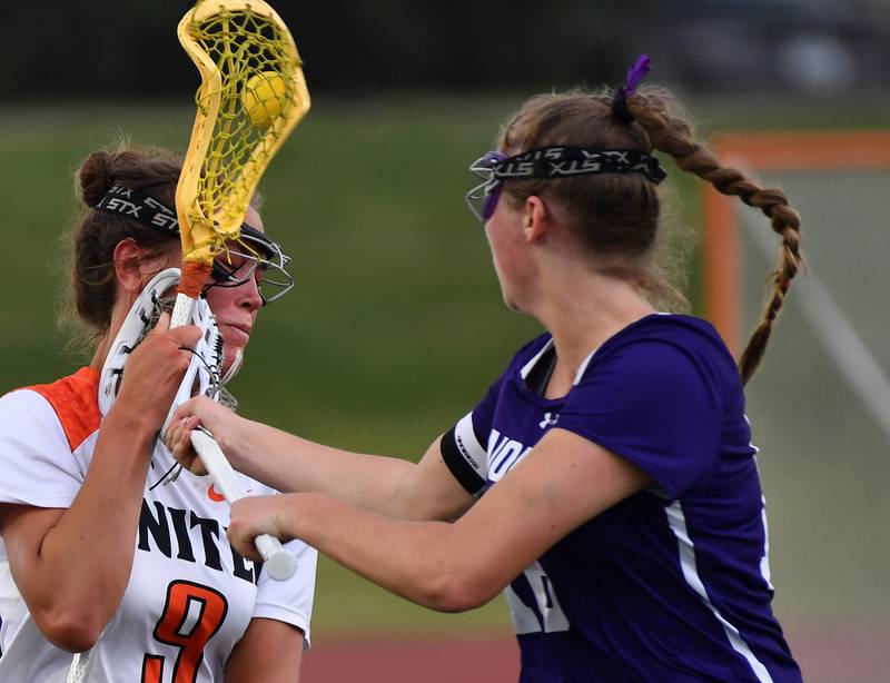 Crystal Lake’s Fiona Lemke (9) catches an accidental stick to her cheek from Downers Grove North’s Ashley Poquette during the Benet Supersectional game on June 3, 2025 at College of DuPage in Glen Ellyn.