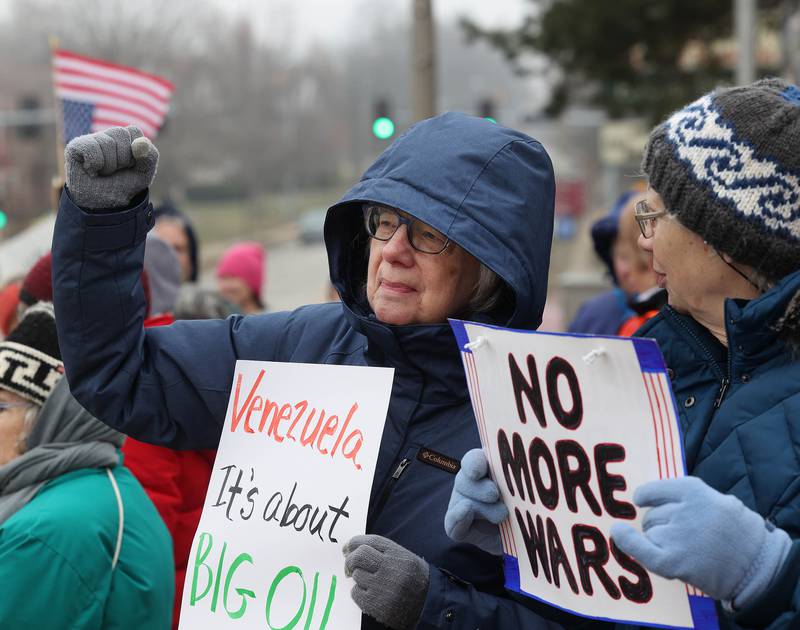 Barbara Andree, (left) from Kingston, holds a sign Tuesday, Jan. 6, 2026, during a Venezuela Rapid Response Rally at Memorial Park on the corner of First Street and Lincoln Highway in DeKalb. The protesters gathered to voice their opposition to President Donald Trump and the administrations recent actions in Venezuela.