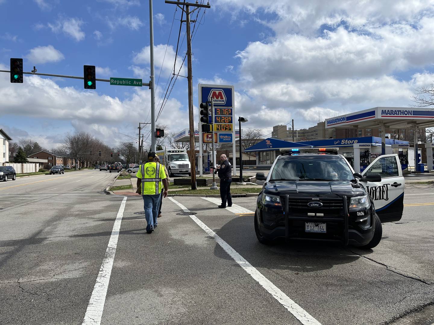 Members of the Joliet Township's violence prevention program Peace Over Violence cross the street as Joliet police officers investigate a shooting on Thursday, March 14, on Republic Avenue in Joliet.
