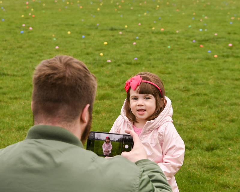 Michael Harkins of Oak Park River Forest takes a picture of his daughter Vivian Gleason, 3, with all the Easter eggs spread out on the baseball field on Saturday April 19, 2025, held at Berens Park in Elmhurst.