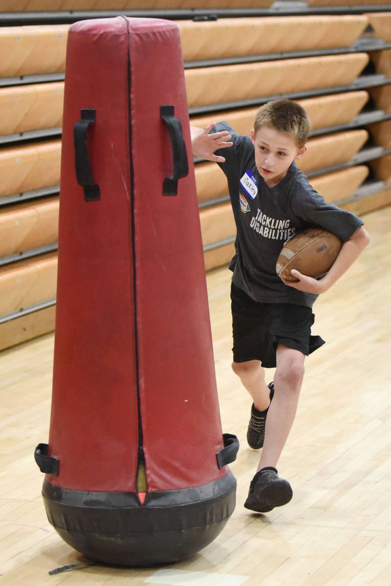 Oakley Price sheds a tackling dummy during a drill at Watseka's Tackling Disabilities football camp Saturday, July 26, 2025.