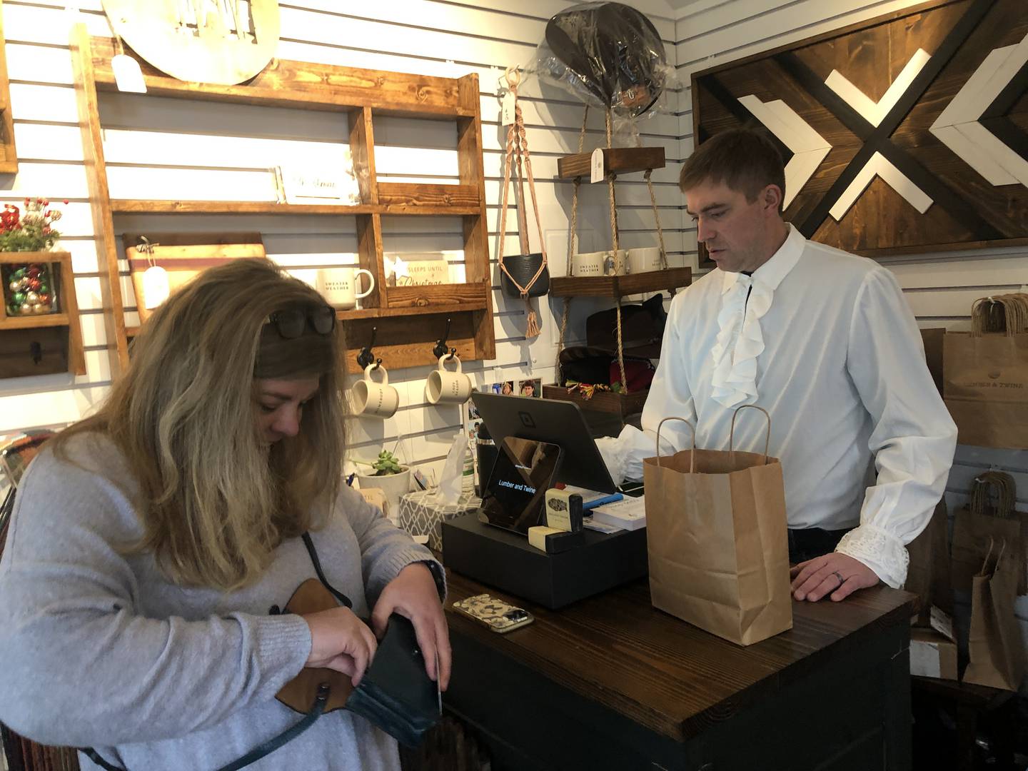 Molly Ostap, left, president of the McHenry Area Chamber of Commerce, was among the shoppers on Saturday, Dec. 23, 2023, as McHenry's Riverwalk Shoppes observed Festivus. David Badgley, of Lumber & Twine, was in the spirit of the holiday with his own puffy shirt.