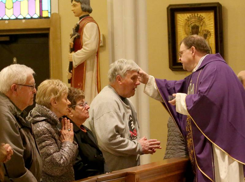 The Very Rev. Gary Blake places ashes on parishioners foreheads during the morning Ash Wednesday Mass on Wednesday, Feb. 22, 2023 at St. Valentines Church in Peru.
