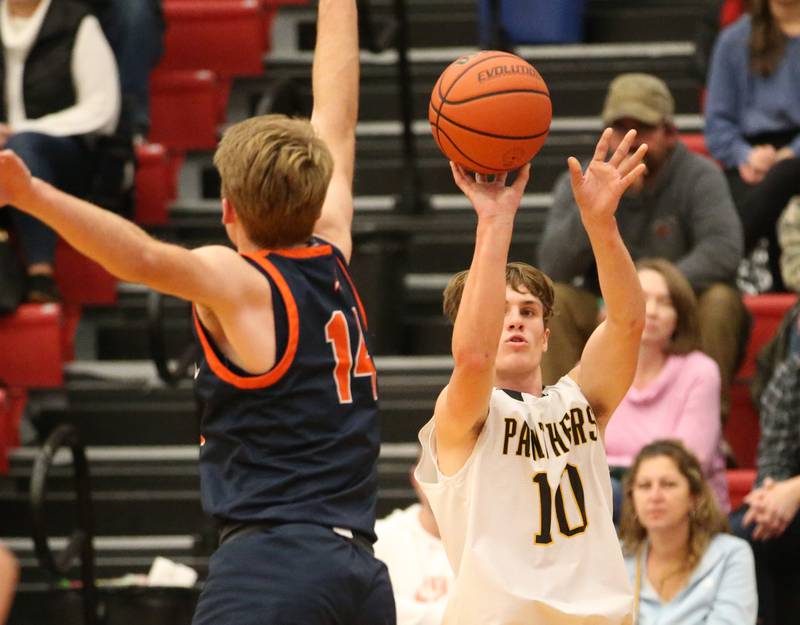 Putnam County's Austin Mattingly (rght) sinks a three point basket over Pontiac's Henry Brummel (left) during the Colmone Classic tournament on Friday, Dec. 9, 2022 at Hall High School in Spring Valley.