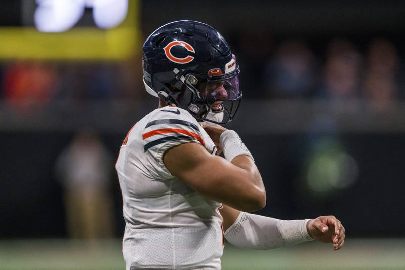 Chicago Bears quarterback Justin Fields rubs his shoulder as he walks back onto the field during the second half against the Atlanta Falcons, Sunday, Nov. 20, 2022, in Atlanta.