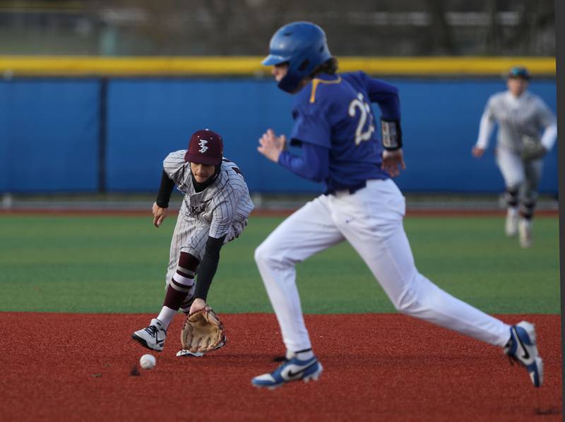 Richmond-Burton's Ryan Scholberg fields the ball as Johnsburg's Jacob Vetter runs to third base during a Kishwaukee River Conference baseball game on Monday, April 6,2026, at Johnsburg High School.