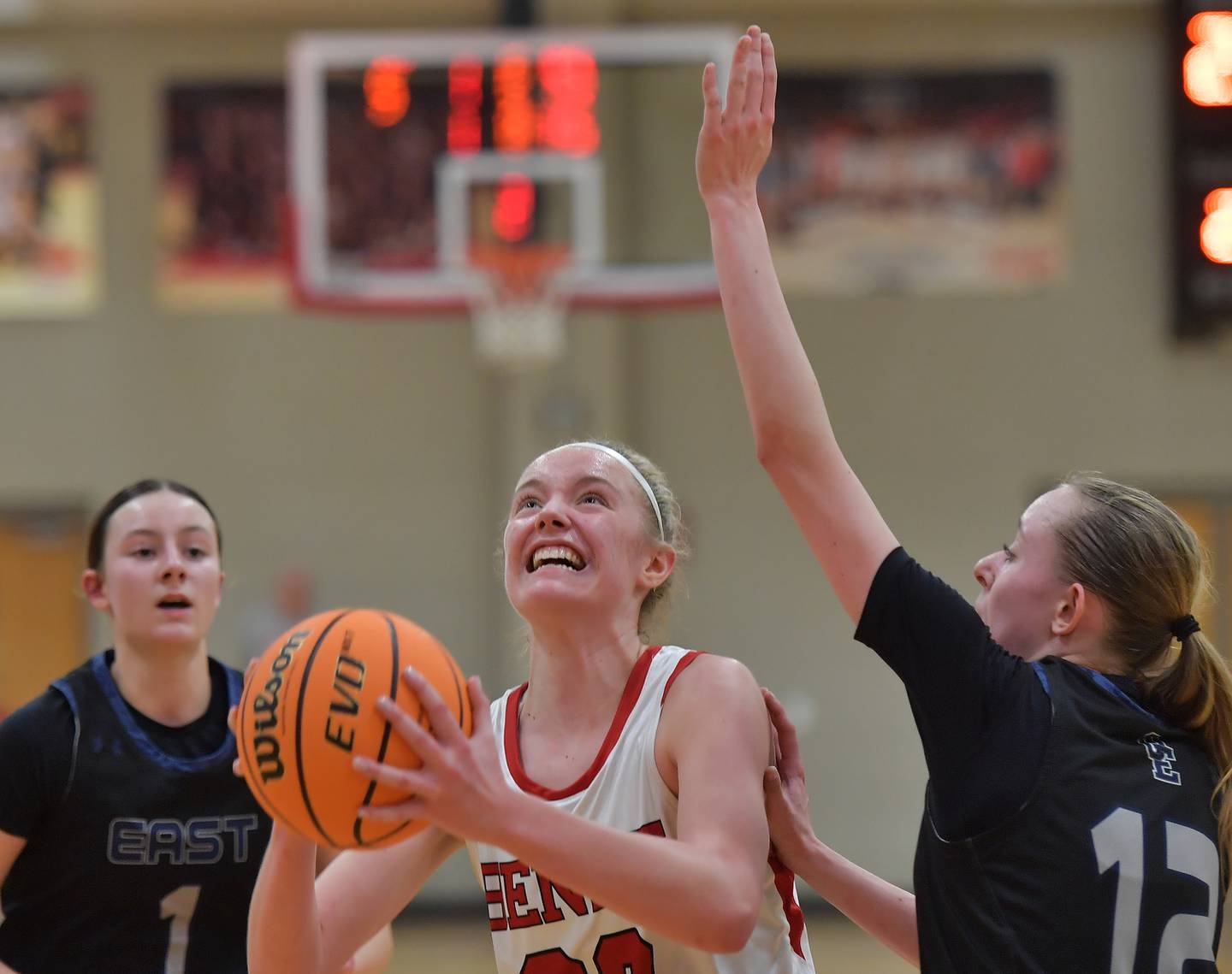Benet’s Bridget Rifenburg goes to the basket between Oswego East’s Aubrey Lamberti (1) and Nicole Warbinski during the Class 4A Benet Regional final on February 19, 2026 at Benet Academy in Lisle.