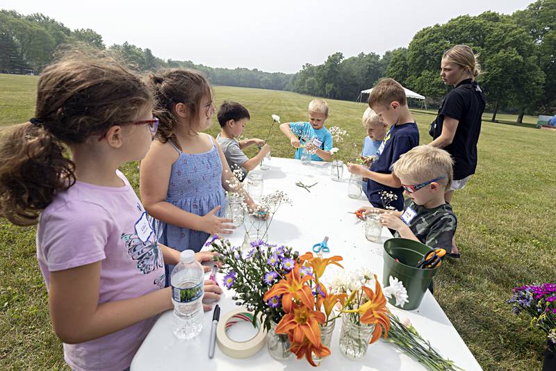 Dianna Robbins, a volunteer from the Whiteside County Farm Bureau, instructs campers on how to trim a nice flower bouquet Thursday, June 29, 2023 as part of a farm camp week.